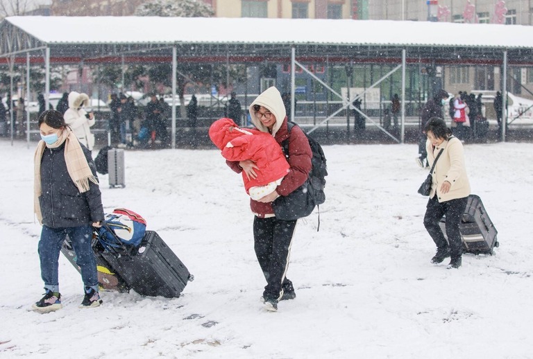 雪の中を歩く旅行者＝２日、中国河南省漯河（らが）駅/Yang Guang/Visual China Group/Getty Images