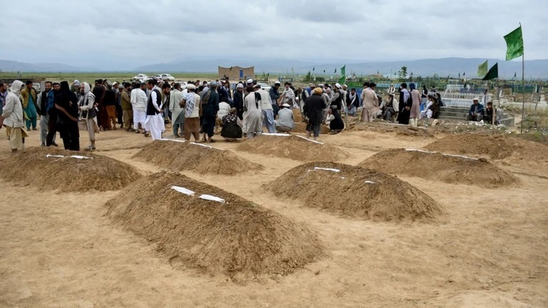 埋葬した遺体に祈りを捧げる遺族ら＝１１日、アフガニスタン・バグラン州/Atif Aryan/AFP/Getty Images