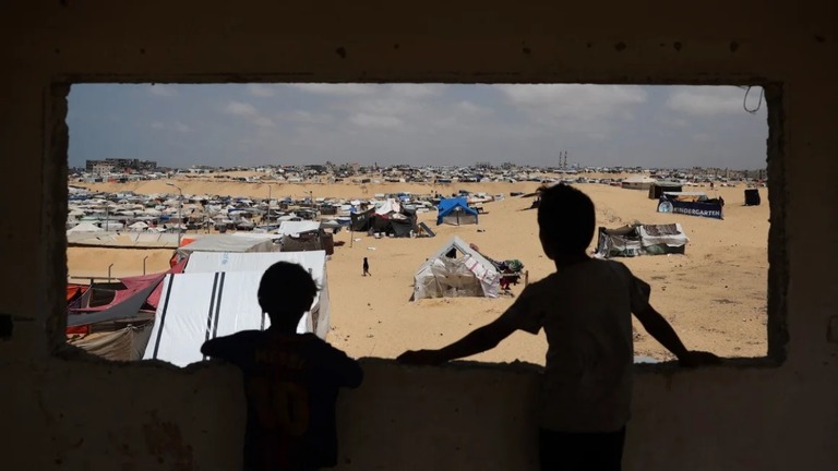 ガザ南部ラファの避難民用キャンプに立つパレスチナ人の子どもたち/AFP/Getty Images