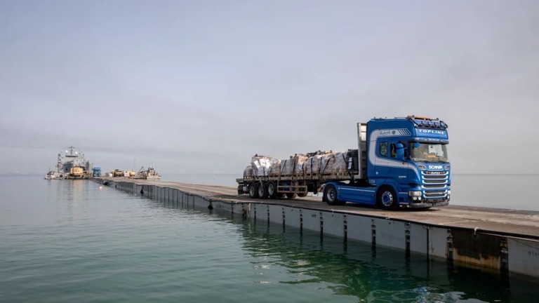桟橋を渡る救援物資を積んだトラック/US Army Central/Reuters