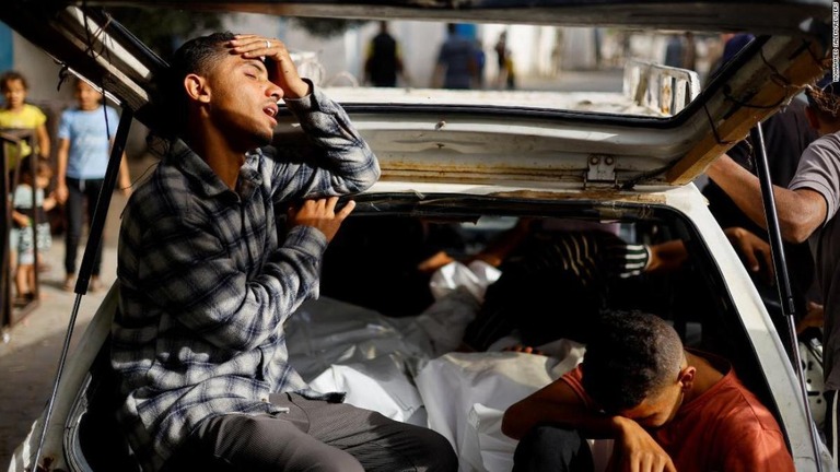 ラファの難民キャンプへの攻撃で死亡した遺体のそばで悲しむ人たち＝２７日、パレスチナ自治区ガザ地区/Mohammed Salem/Reuters