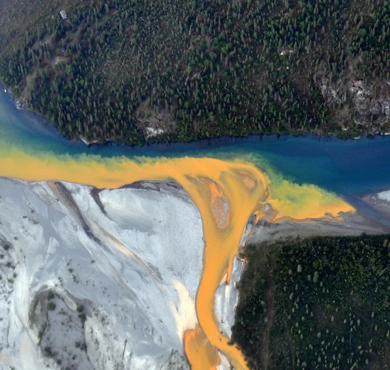 青く澄んだ河川の水にオレンジ色の塗料を流し込んだように見えるクタック川の航空写真/Ken Hill/National Park Service