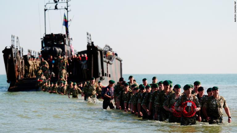 式典の一環でノルマンディーの海岸に上陸する英国海兵隊員/Aaron Chown/AP