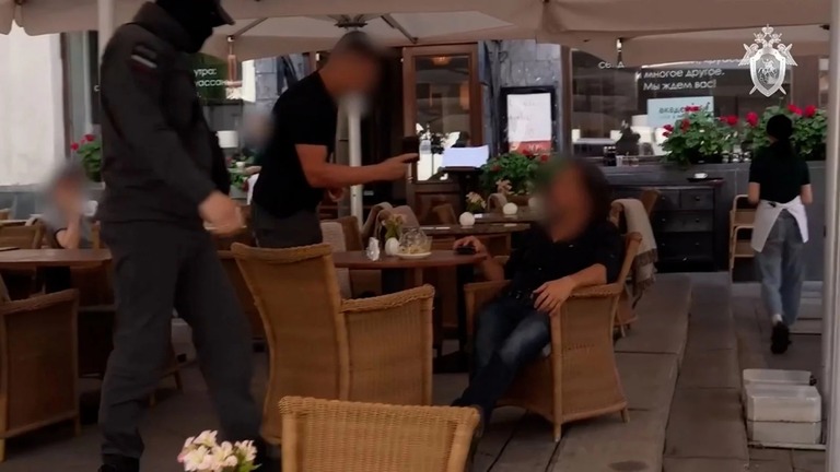 ロシア連邦捜査委員会（ＩＣＲＦ）が公開した動画には男性がモスクワ市内のカフェで治安要員に拘束され、軍の車両に乗せられる場面が映っていた/Russian Investigative Committee