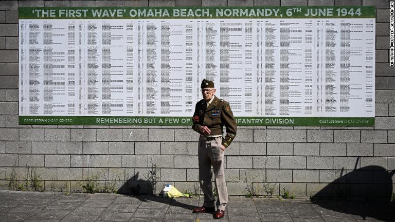 第２次大戦時代の服を着て掲示板の前に立つ男性＝英イングランド・ポートランド＝６日/Finnbarr Webster/Getty Images