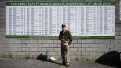 第２次大戦時代の服を着て掲示板の前に立つ男性＝英イングランド・ポートランド＝６日