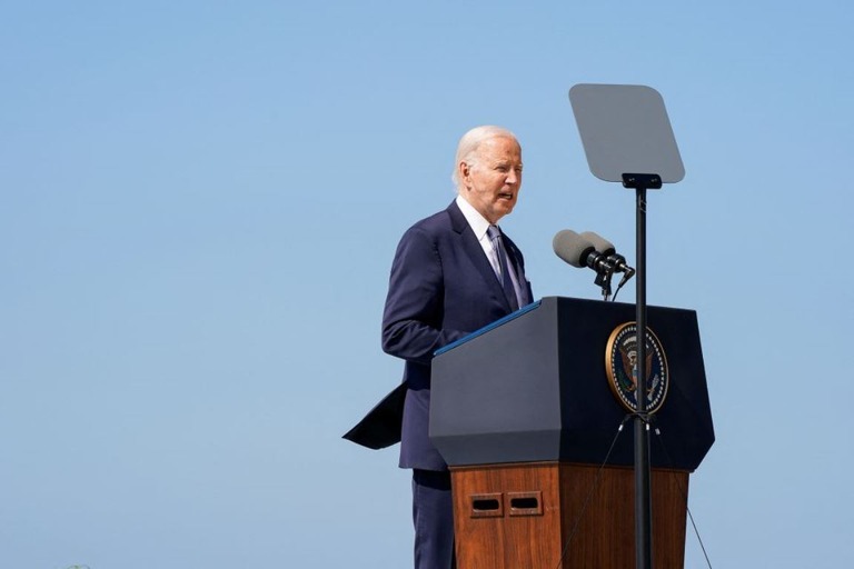 ノルマンディー上陸作戦の激戦地オック岬に設置された演壇に立ち、演説するバイデン氏/Elizabeth Frantz/Reuters