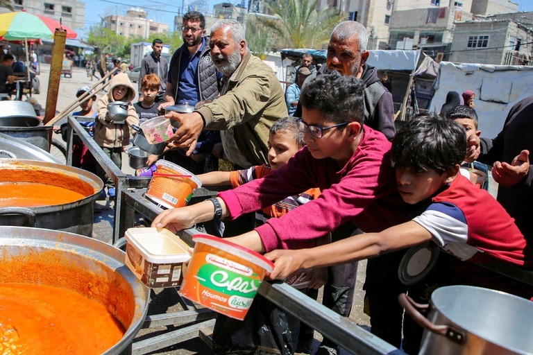 支援団体からの食料を受け取りに来た子どもら＝５月８日、パレスチナ自治区ガザ地区南部ラファ/Hatem Khaled/Reuters