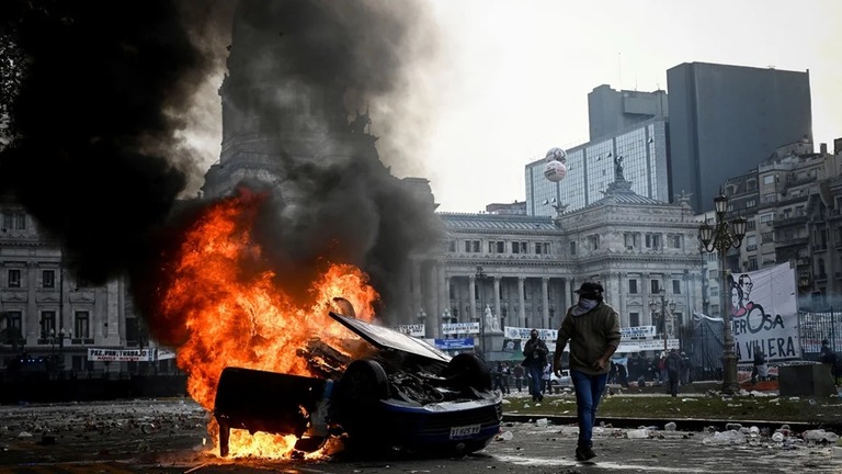 炎上する車両＝１２日、ブエノスアイレスのアルゼンチン国会議事堂付近/Mariana Nedelcu/Reuters
