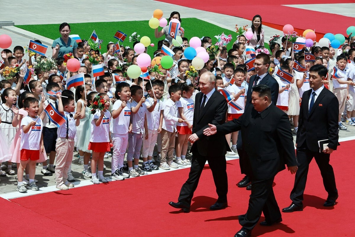 国旗や風船を持った子どもたちに迎えられるロシアのプーチン大統領＝１９日、北朝鮮・平壌の金日成広場/Vladimir Smirnov/Sputnik/Pool/Reuters