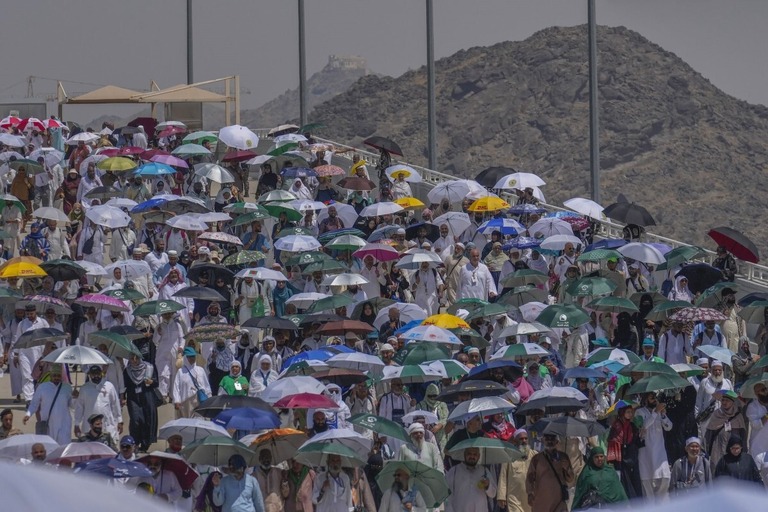 日差しよけのため傘をさすイスラム教の巡礼者ら＝１８日、メッカ近郊/Rafiq Maqbool/AP