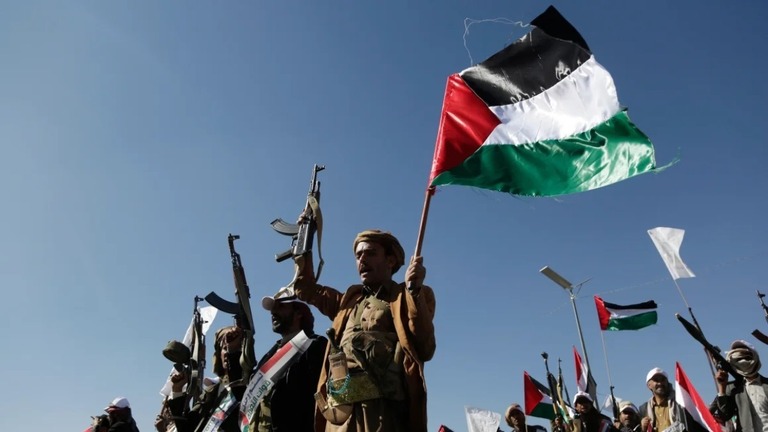 イエメンでフーシの訓練を受けた人々が銃とパレスチナの旗を掲げる＝昨年１２月/Mohammed Hamoud/Getty Images/File