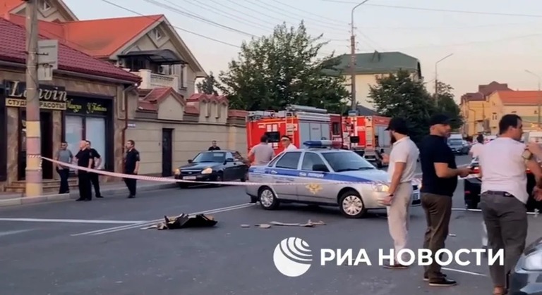 ２３日、ロシア南部ダゲスタン共和国の首都マハチカラで発生した襲撃事件の現場に駆けつける警官ら/RIA Novosti