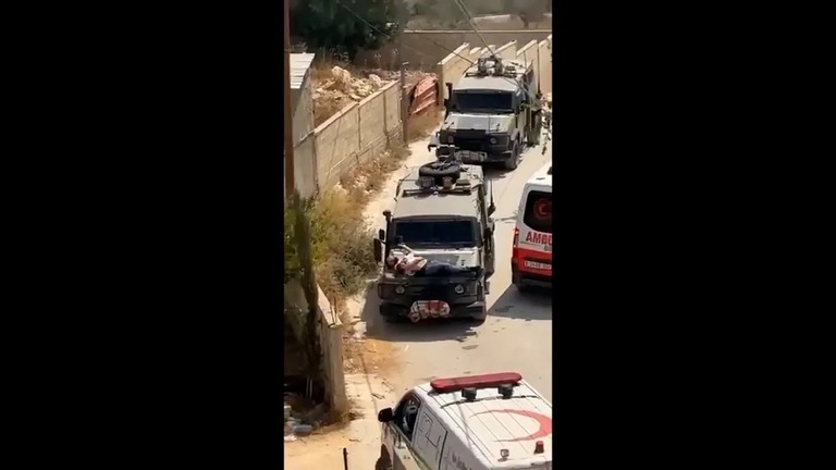 軍用車両のボンネットに、負傷したパレスチナ人の男性が拘束されているのが目撃された/Palestine Red Crescent/X