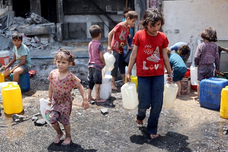 水をためた容器を運ぶパレスチナの子どもたち＝３日、パレスチナ自治区ガザ地区北部ジャバリヤ/Omar Al Qatta/AFP/Getty Images