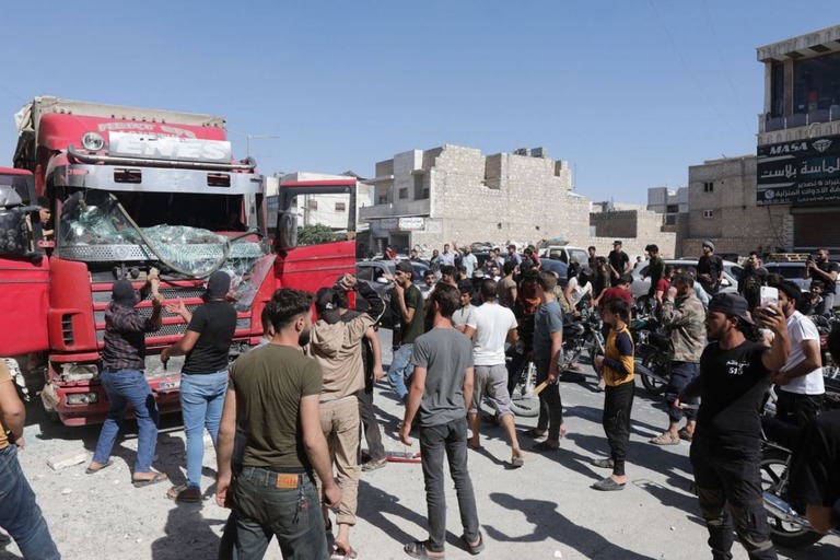 トルコに対するデモのさなか、トルコのトラックを襲う人たち＝１日、シリア・アレッポ/Bakr Alkasem/AFP/Getty Images