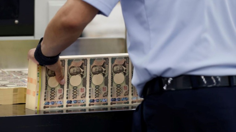 新しい１万円札のシートを扱う職員＝６月１９日、東京の国立印刷局/Kiyoshi Ota/Bloomberg/Getty Images