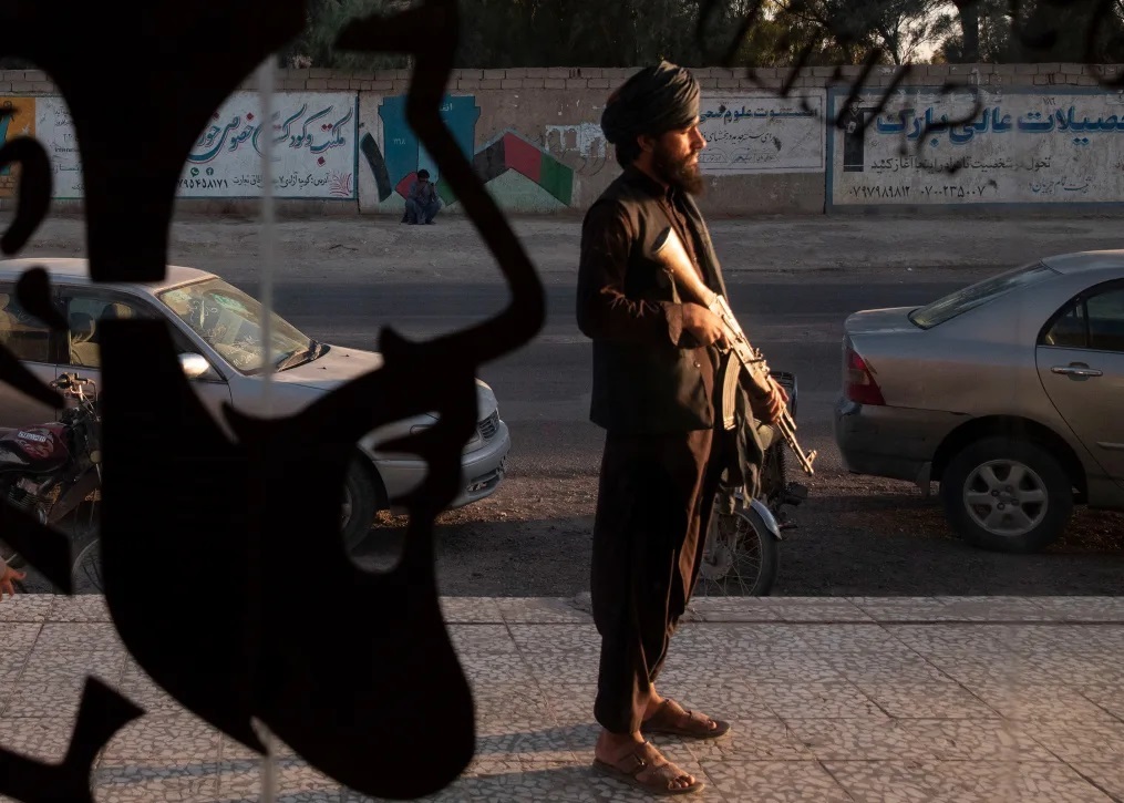 南西部ニームルーズ州の州都ザランジュにある男性向け理容店の前に立つタリバンの兵士/Majid Saeedi/Getty Images/File