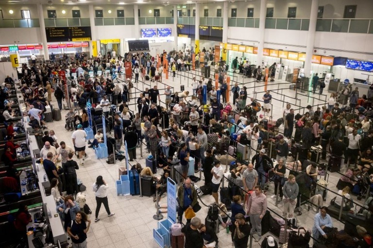 大規模障害の発生時、旅行客が列をなす英ロンドン・ガトウィック空港の様子/Jack Taylor/Getty Images