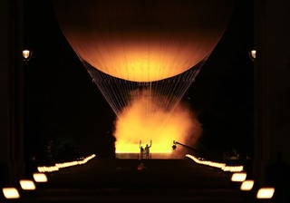 聖火台が熱気球で空に上がるのを見守るフランスの柔道選手テディ・リネール（右）とマリー・ジョゼ・ペレク＝２６日、パリ