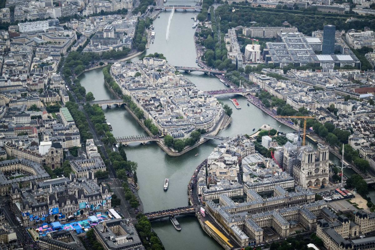 ノートルダム大聖堂の空撮写真。横を流れるセーヌ川をボートが下っている/Lionel Bonaventure/Pool/AFP/Getty Images