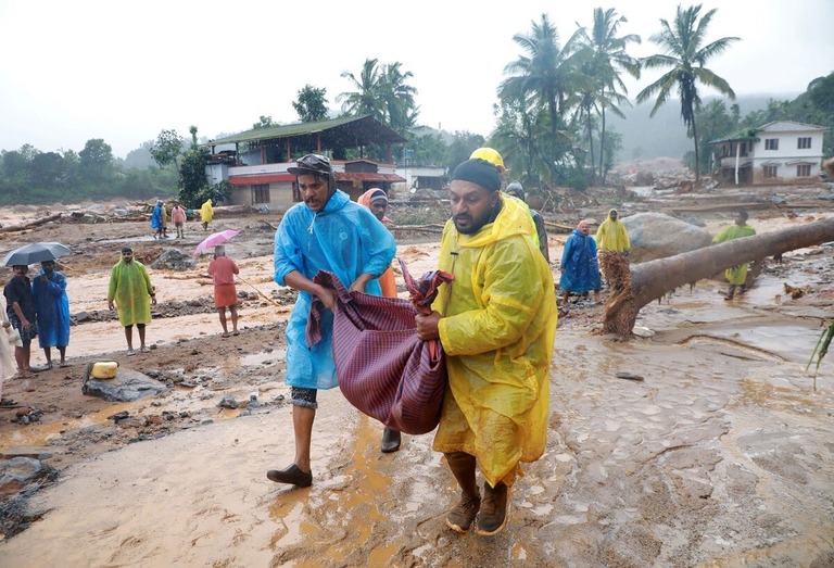 土砂崩れの発生現場で犠牲者の遺体を運ぶ救助隊＝３０日、インド南部ケララ州ワヤナド地区/Stringer/Reuters