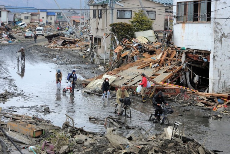 津波や地震の被害を受けた道路を移動する住民＝２０１１年３月、宮城県石巻市/Kim Jae-Hwan/AFP/Getty Images