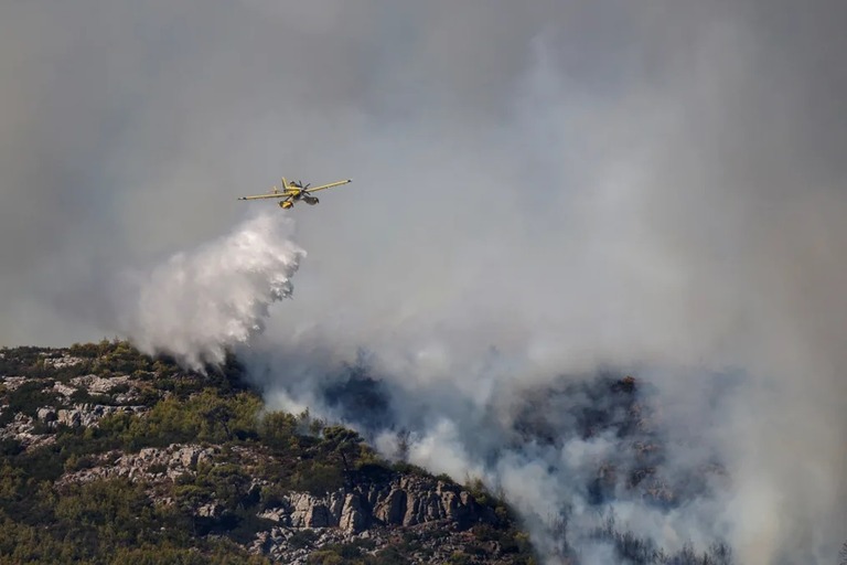 山火事が発生した地域に放水する消防機＝１２日、アテネ近郊グラマティコ/Alexandros Avramidis/Reuters