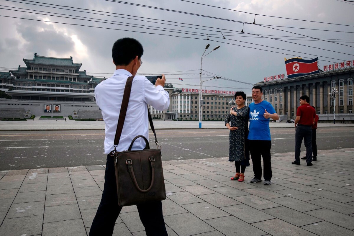 金日成広場で記念撮影をする中国からの観光客＝２０１９年/Ed Jones/AFP/Getty Images