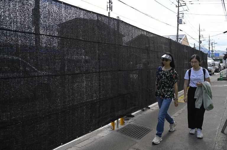 コンビニエンスストア前の歩道に設置された幕＝５月２１日、山梨県の富士河口湖町/David Mareuil/Anadolu/Getty Images