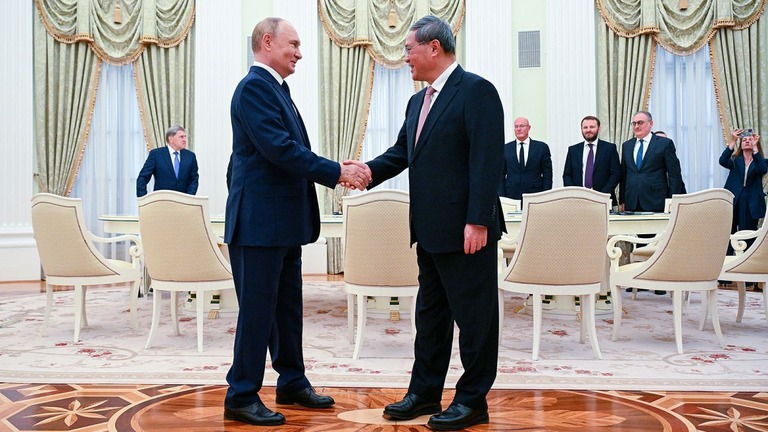 握手を交わすロシアのプーチン大統領（左）と中国の李強首相/Alexey Filippov/POOL/AFP/Getty Images