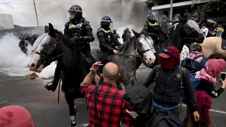 展示会の会場前で警察と対峙するデモ隊/William West/AFP/Getty Images