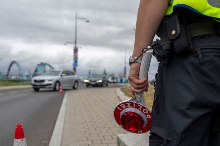 車が近づいて来るのを待つドイツの警官/Maja Hitij/Getty Images