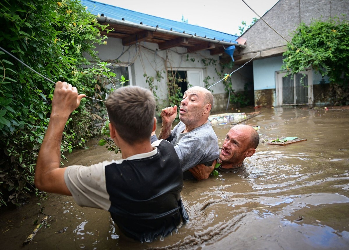 洪水した地域から救出される男性＝ルーマニア/Daniel Mihailescu/AFP/Getty Images