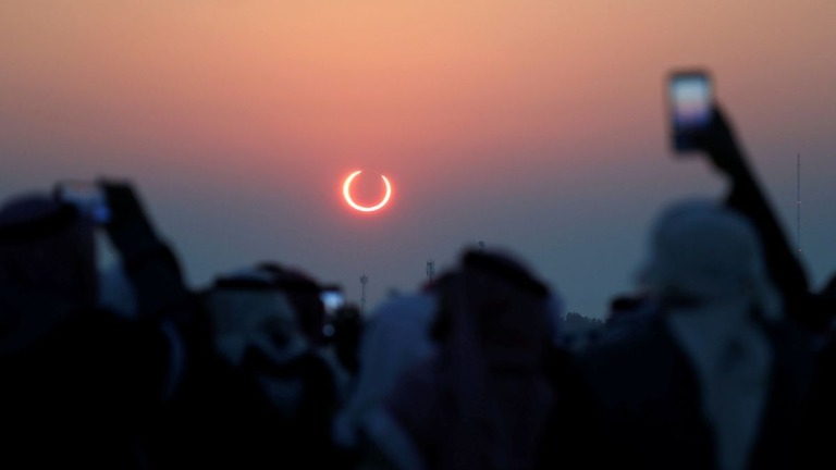 ２０１９年１２月、サウジアラビアで観測された日食をカメラで撮影する人々/Hamad I Mohammed/Reuters