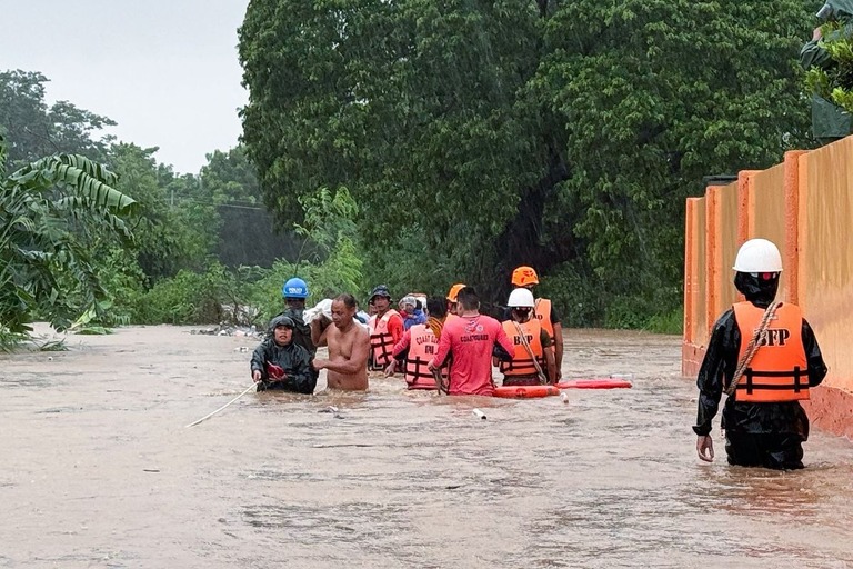 フィリピンの北イロコス州を襲った台風による洪水被害から住民を救出する救急隊員/Bernie Dela Cruz/AP via CNN Newsource