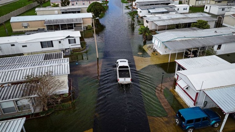 フロリダ州サウスデイトナの冠水した道路を走行するトラック/Miguel J. Rodriguez Carrillo/AFP/Getty Images