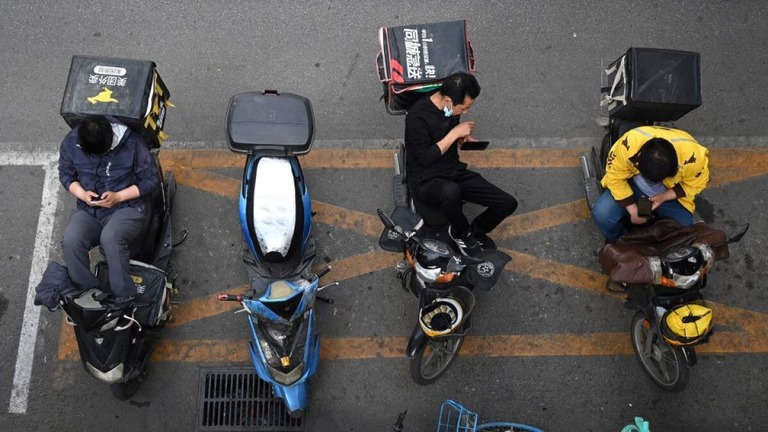 レストランの外で配達の順番を待つ配達員＝２０２１年５月１８日、中国・北京
/Greg Baker/AFP/Getty Images