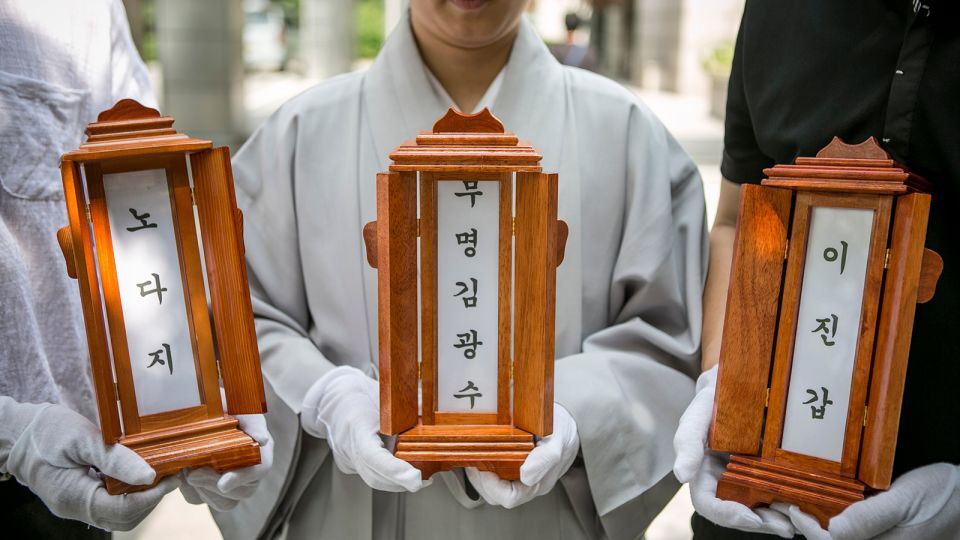 死亡した３人の位牌を手にする尼僧と慈善団体のスタッフ/Jean Chung/Getty Images