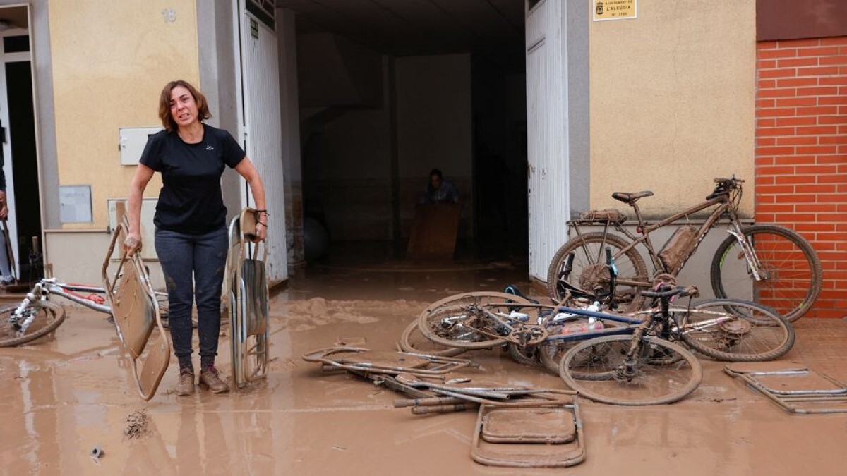 洪水により泥で覆われた椅子を運ぶ女性＝スペイン・バレンシア州/Eva Manez/Reuters