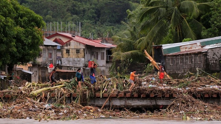 暴風雨の影響を受けた橋を渡る住民＝１０月２３日、マニラ南部アルバイ州/Charism Sayat/AFP/Getty Images