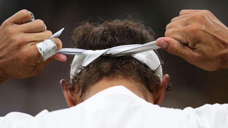 ２０１８年のウィンブルドン準決勝の前にヘッドバンドを結ぶナダル/Daniel Leal/Pool/AFP/Getty Images