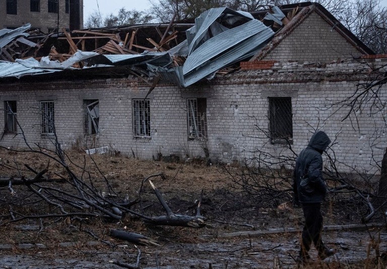 ロシアのミサイル攻撃を受けた場所を歩く住民＝２１日、ウクライナ東部ドニプロ/Mykola Synelnykov/Reuters