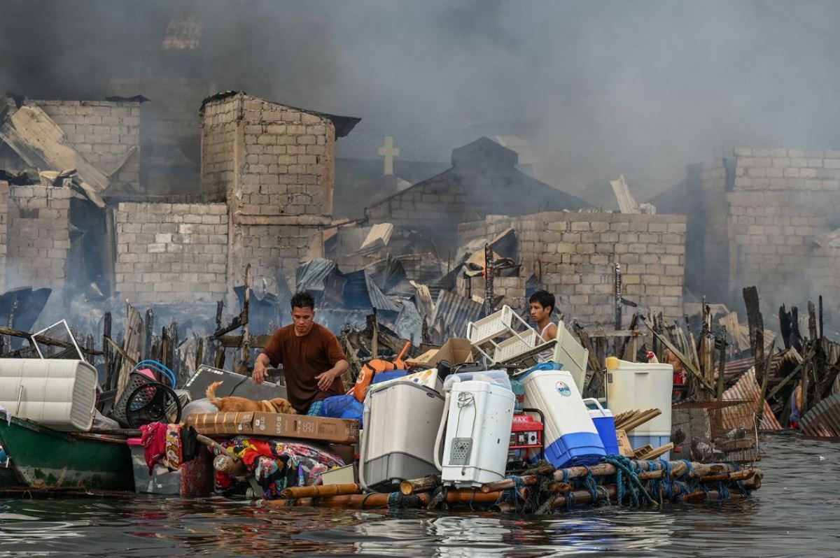 間に合わせのいかだで家財を運び出す人たち/Jam Sta Rosa/AFP/Getty Images