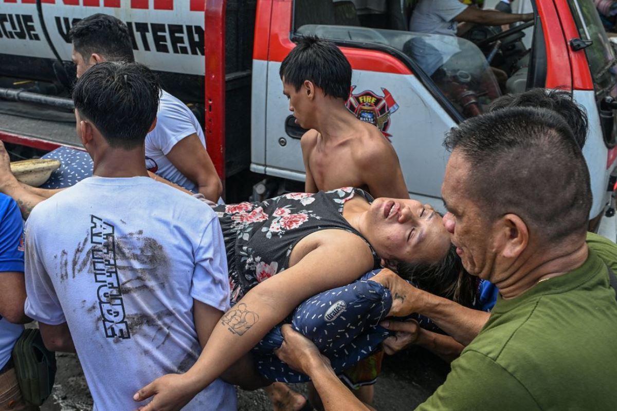 運ばれる気絶した女性/Jam Sta Rosa/AFP/Getty Images