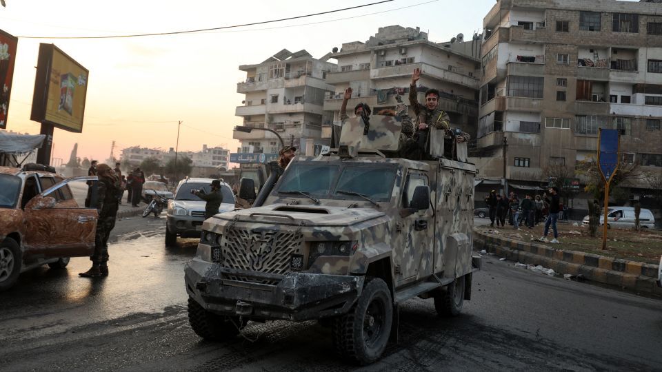 軍用車に乗りながら歓喜の声を上げる反体制派の戦闘員＝５日、ハマ/Abdulaziz Ketaz/AFP/Getty Images