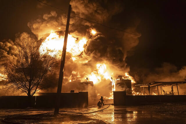 ロシア軍の攻撃を受けた住宅街で消防士が消火活動にあたっている＝２月１０日、ウクライナ・ハルキウ/Yevhen Titov/AP