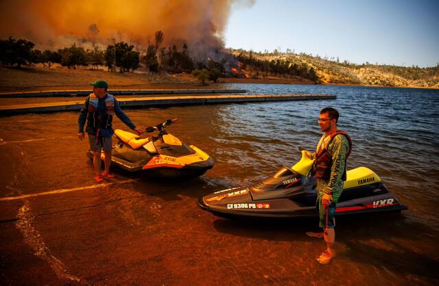 カリフォルニア州北部オロビルで山火事を見つめる人々。同地では数千人に対して避難命令が出された＝７月２日/Ethan Swope/AP