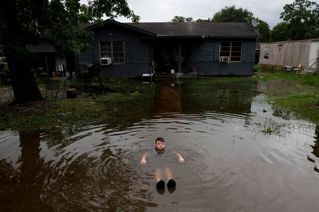 米テキサス州ローゼンバーグの家の外で水に浸かる少年。ハリケーン「ベリル」は約４０年で同州に最も早い時期に上陸したハリケーンとなった＝７月８日/Daniel Becerril/Reuters