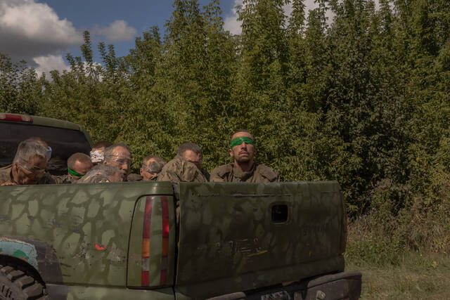 ロシア軍の軍服を着た男性を目隠しをして運ぶウクライナ軍車両＝８月１３日、ウクライナ・スムイ/Roman Pilipey/AFP/Getty Images